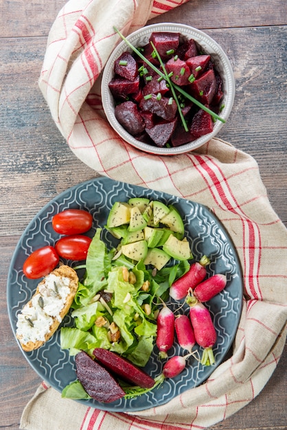 Schüsseln und Teller mit gesunden veganen Salat