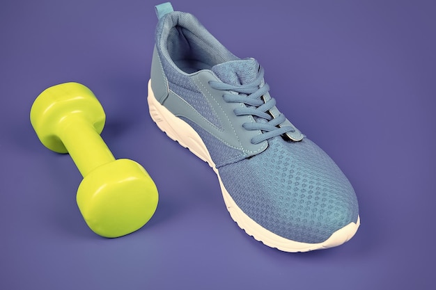 Schuhe für das Training mit Hantel auf blauem Hintergrund Sportzubehör