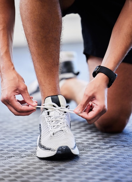 Schuhe Läufer und Mann bereiten sich auf Trainingsübungen vor oder laufen in Sportschuhen Mode und Fuß auf dem Boden Füße von Sportlern oder Personen, die ihre Schnürsenkel für Cardio-Fitness oder Training im Fitnessstudio binden