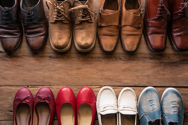 Schuhe mit verschiedenen Arten der Männer und der Frauen auf einem Bretterboden - Lebensstile.