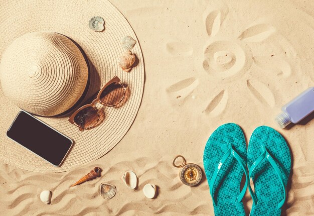 Schuhe und Hut am Strand