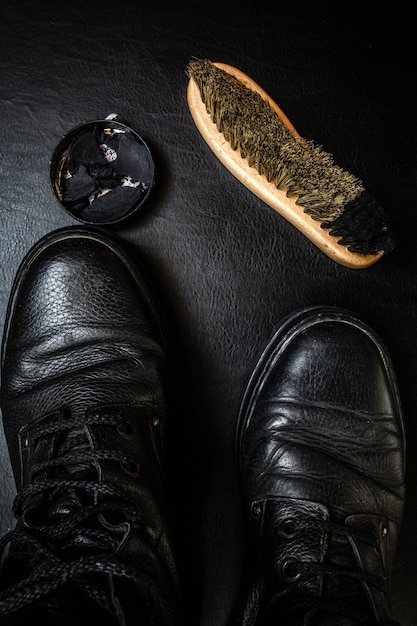 Schuhpflege Schuhwachs, Stiefel und Bürsten auf Holzoberfläche