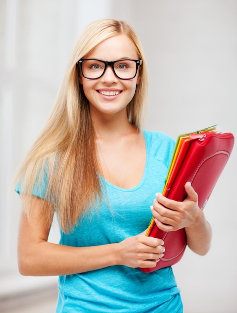 Schul- und Bildungskonzept - lächelnder Schüler mit Ordnern