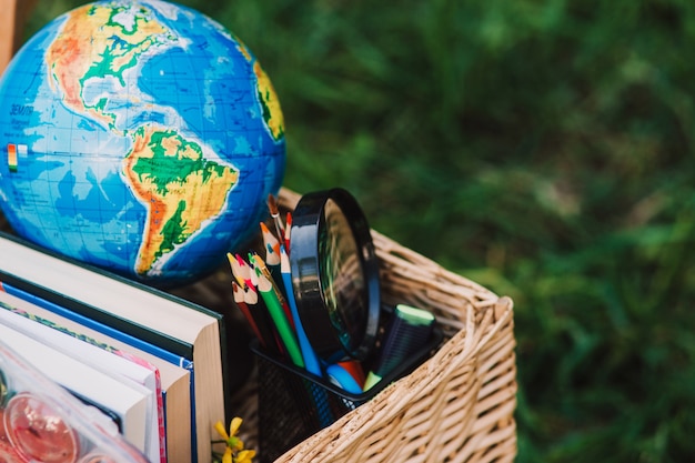 Foto schulausrüstung, bücher und globus im korb