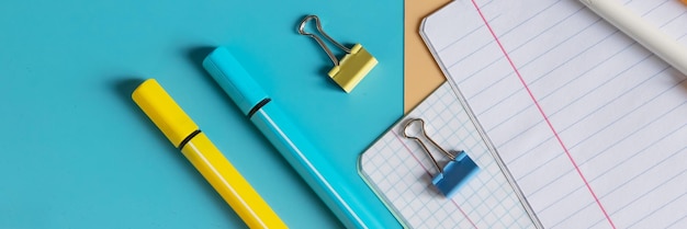 Schulbriefpapier, Farbstifte, Farben, Notizblock auf blauem Tisch, zurück zum Schulhintergrund, Kinderschreibtischplatte