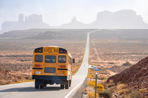 Schulbus fährt im Sommer auf der Straße in Richtung Monument Valley