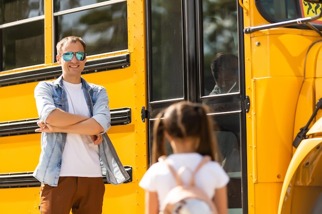 Schulbusfahrer steht vor seinem Bus