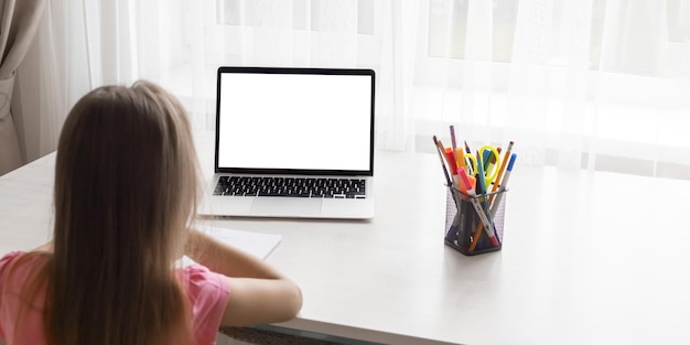 Schule zu Hause durch Online-Homeschooling sitzt das Kind am Computer