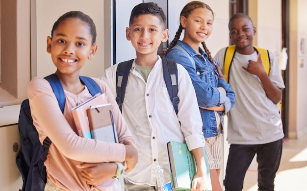 Schulfreundschaft und Porträt einer Gruppe von Kindern, die mit Rucksack und Büchern im Flur stehen Bildungsvielfalt und Wissen Glückliche junge Schüler lächeln gemeinsam außerhalb des Klassenzimmers in den USA