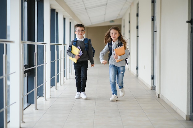 Schuljunge mit Schultasche und Büchern in der Schule Bildungskonzept Zurück zur Schule Schulkind, das zur Klasse geht Stilvoller Junge mit Rucksack Junge bereit zu studieren