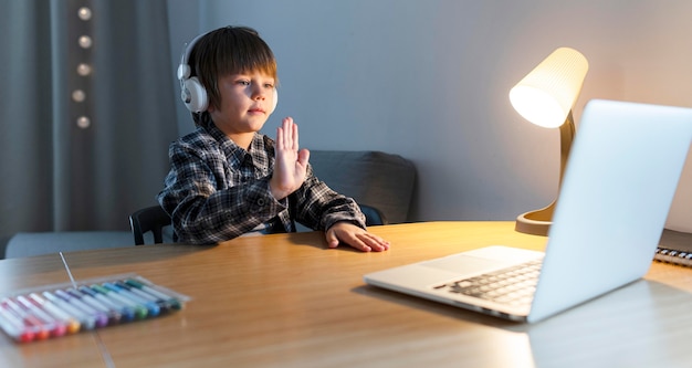 Foto schuljunge nimmt an online-kursen teil und winkt