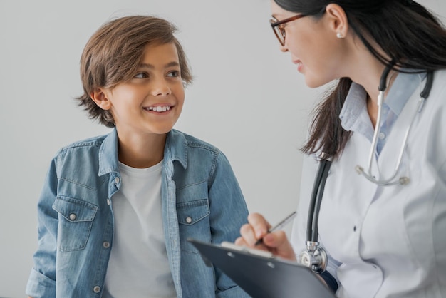 Schuljunge und Arzt beraten sich im Krankenzimmer