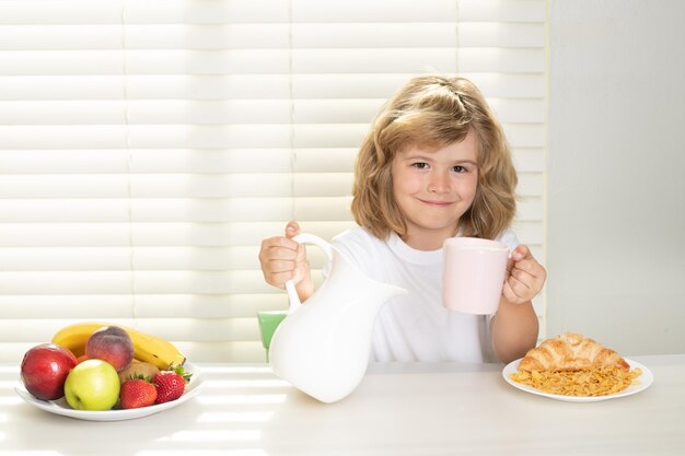 Schulkind, das ganze Kuhmilch zum Frühstück gießt, Kind, jugendlicher Junge, Jahre alt, der gesundes Gemüse isst