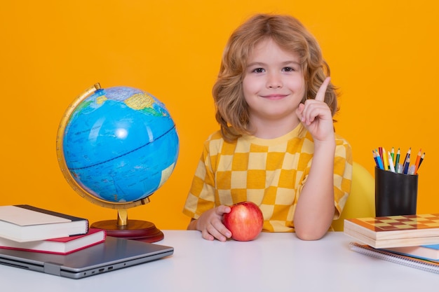 Schulkind hält den Zeigefinger hoch und zeigt eine tolle neue Idee. Schulkind lernt in der Schule Sprache oder Literatur. Grundschulkind. Porträt eines Nerd-Schülers beim Lernen