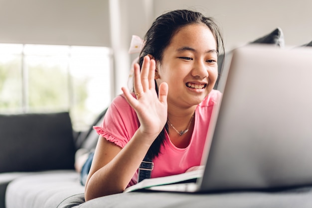 Schulkind kleines Mädchen lernen und betrachten Laptop-Computer machen Hausaufgaben lernen Wissen mit Online-Bildung E-Learning-System.Kinder Videokonferenz mit Lehrer Tutor zu Hause