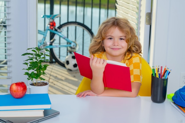 Schulkind liest Buch zurück zur Schule. Lustiges kleines Kind aus der Grundschule mit Bucherziehung