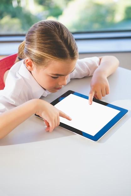 Schulkind mit digitalem Tablet im Klassenzimmer