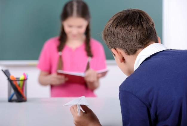 Schulkinder, die auf Tafel lernen.