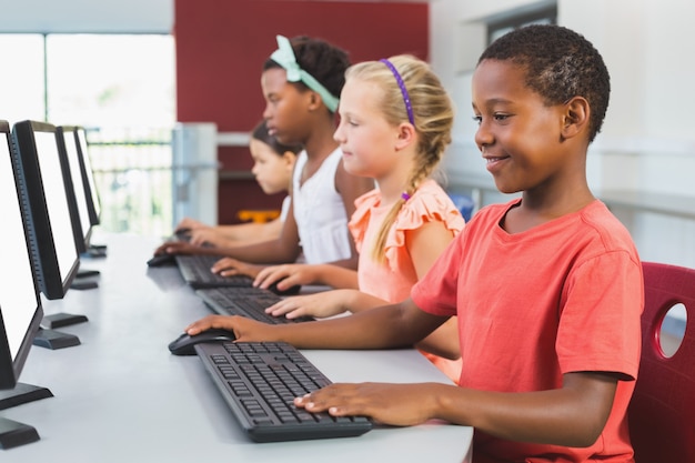 Schulkinder, die Computer im Klassenzimmer benutzen
