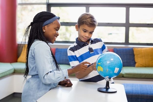 Schulkinder, die Kugel in der Bibliothek betrachten