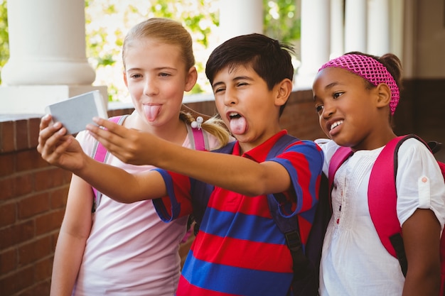 Schulkinder, die selfie im Schulkorridor nehmen