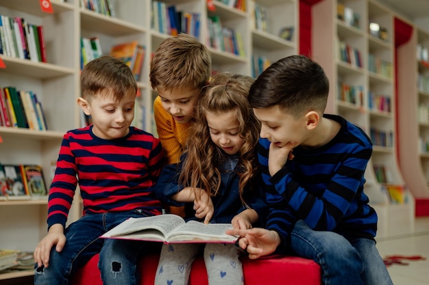 Schulkinder in der Bibliothek lesen Bücher, machen Hausaufgaben, bereiten ein Schulprojekt für den Unterricht vor