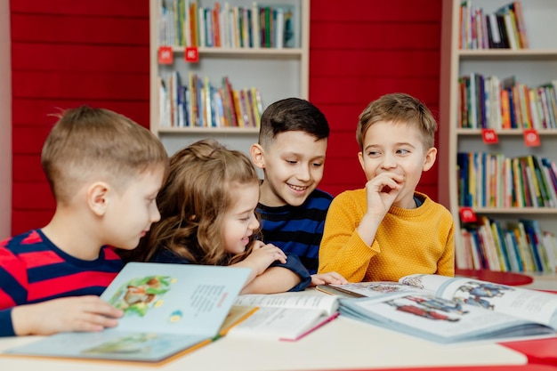 Schulkinder in der Bibliothek lesen Bücher, machen Hausaufgaben, bereiten ein Schulprojekt für den Unterricht vor