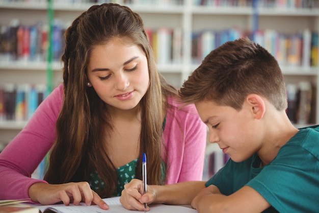 Schulkinder machen Hausaufgaben in der Bibliothek in der Schule