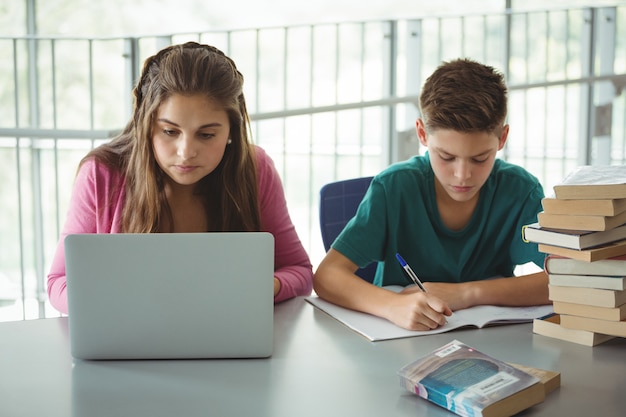 Schulkinder machen Hausaufgaben in der Bibliothek