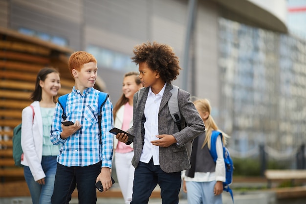 Schulkinder mit Geräten im Freien