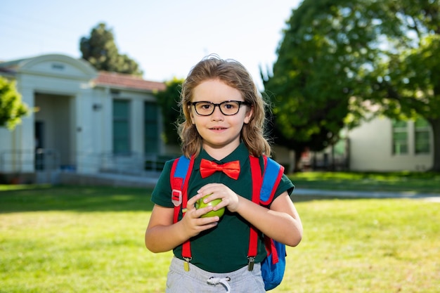 Schulkindkonzept süßes Schülerkind in Schuluniform mit Rucksack Outdoor-Porträt von Nerd-Schüler