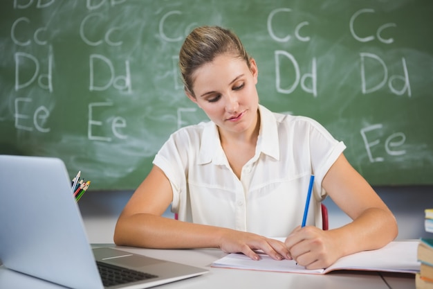 Schullehrer prüft Buch im Klassenzimmer