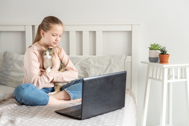 Schulmädchen, das zu Hause mit Laptop lernt. Online-Bildung, Quarantänekonzept