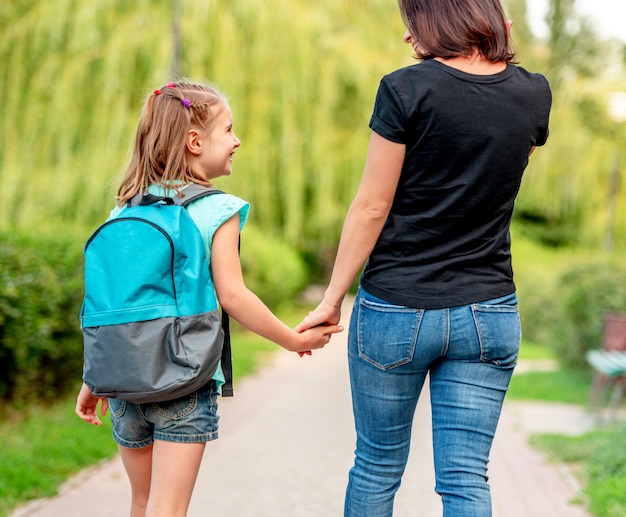 Schulmädchen geht mit Mutter nach Hause