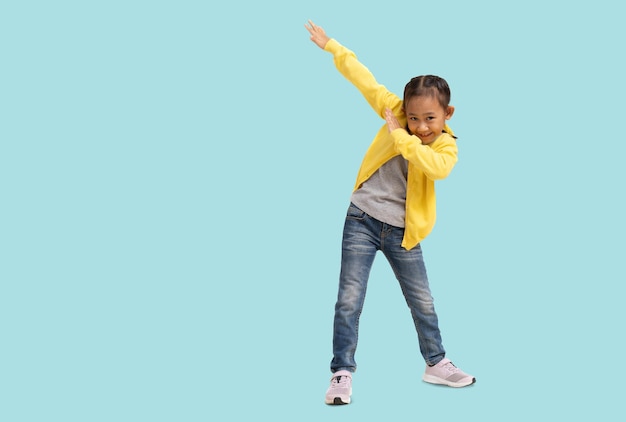 Schulmädchen glückliche asiatische Schülerin Schulkind handtanzender Superheld Ganzkörperporträt isoliert auf pastellfarbenem, schlichtem hellblauem Hintergrund