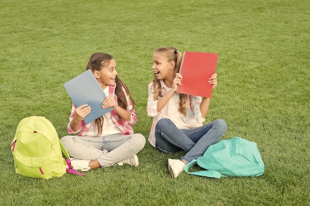 Schulmädchen kleine Kinder Schulhof mit Büchern informelles Bildungskonzept