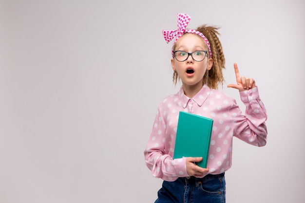 Schulmädchen mit Brille mit einem Buch