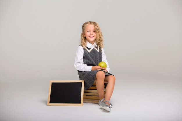 Schulmädchen mit Büchern auf einem hellen Hintergrund