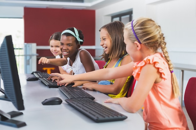 Schulmädchen mit Computer im Klassenzimmer