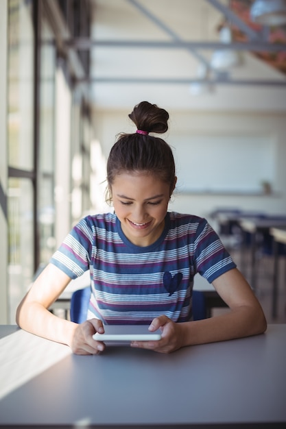 Schulmädchen mit digitalem Tablet im Klassenzimmer