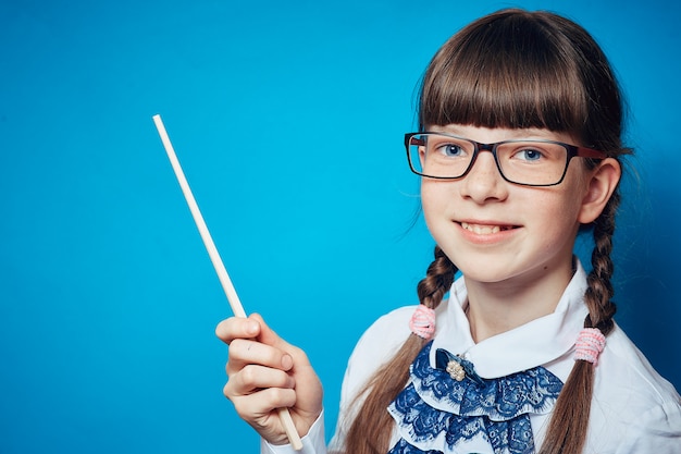 Schulmädchen mit Gläsern und einem Zeiger auf einem blauen Hintergrund