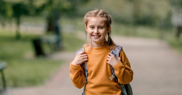 Schulmädchen mit Rucksack im Freien