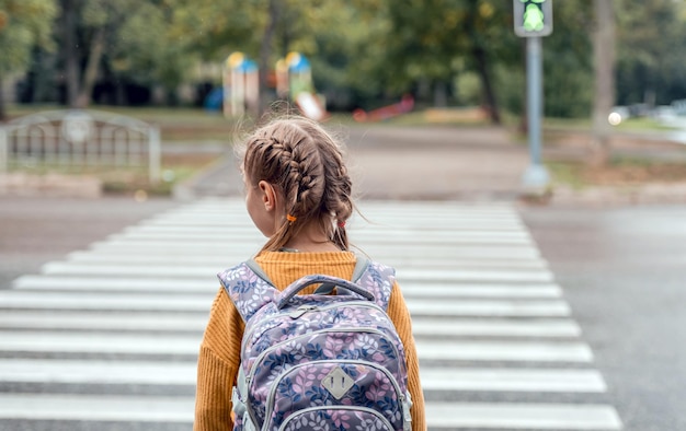 Schulmädchen mit Rucksack im Freien