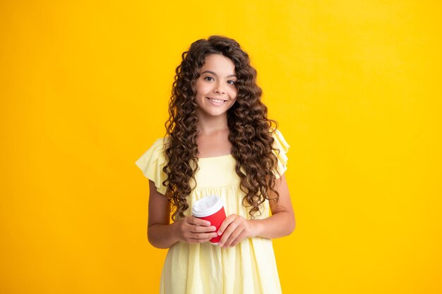 Schulmädchen mit Tasse Cappuccino oder Tee zum Mitnehmen Kind mit Plastikbecher zum Mitnehmen Morgengetränk Kakaogetränk Glückliches Teenager-Porträt Lächelndes Mädchen