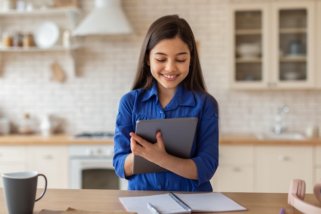 Schulmädchen nutzt Tablet-Computer zu Hause und lernt online mit Spaß