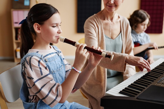 Schulmädchen spielt mit Lehrer Musikinstrumente