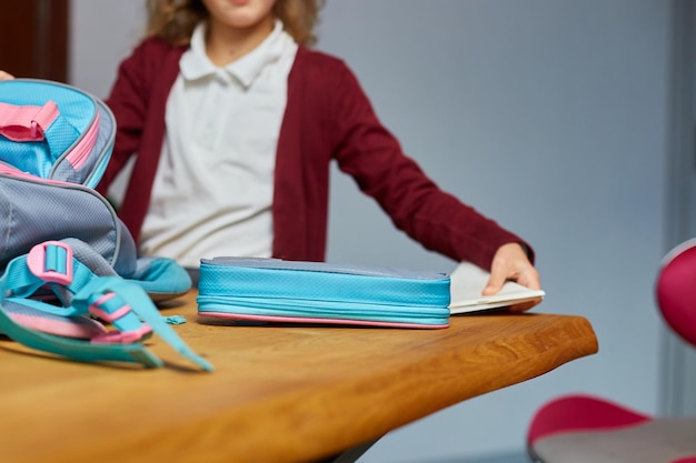 Schulmädchen steckt Bücher und Notizen in den Rucksack zu Hause. Schülerin bereitet Personal auf Bildung vor