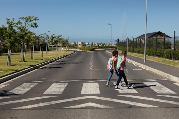 Schulmädchen überqueren die Straße auf einem Fußgängerüberweg