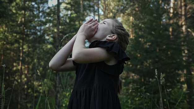 Schulmädchen verirrt sich im dunklen Wald und schreit weinend in der Nähe