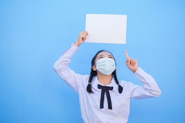 Schulmädchen zeigen Plakatwand auf blauem Hintergrund